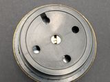 a close up of a metal button on a gray surface