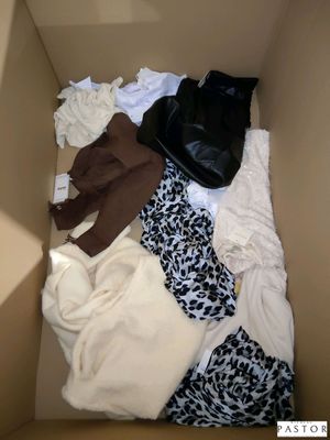 une boîte remplie de vêtements et une paire de chaussures