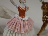 a figurine of a ballerina with a deer in the background
