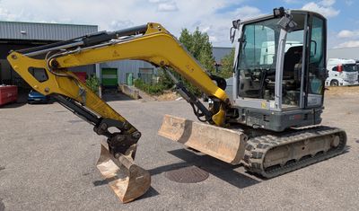 a picture of a small excavator parked in a parking lot