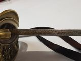 a metal object that is on a table with a leather strap