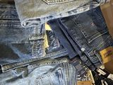 several pairs of jeans stacked on top of each other in a box
