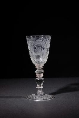a close up of a glass on a table with a black background
