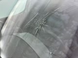 a broken windshield of a car with a bullet hole in it