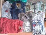 une boîte remplie de t-shirts et d'autres objets posée par terre