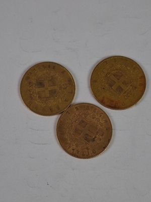 three coins sitting on top of a white surface next to each other