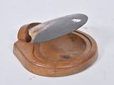 a knife that is sitting on top of a wooden plate