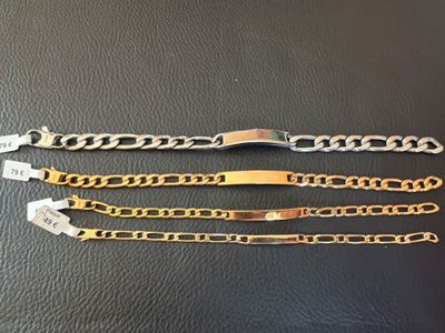 deux bracelets en or et en argent sur un fond en cuir noir