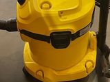 un aspirateur jaune posé par terre à côté d'un poteau
