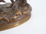 a bronze statue of a bird on a tree branch