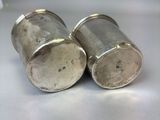 two silver salt and pepper shakers sitting on a table