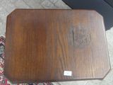 a small wooden table with a wooden top on a rug