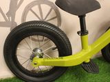 a yellow bicycle with a black seat and a green tire