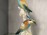 deux figurines d'oiseaux posées sur une table en verre