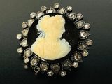 une photo d'une broche-camée en noir et blanc sertie de diamants