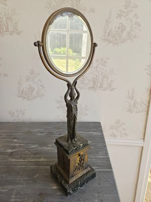 un miroir posé sur une table sur laquelle se trouve une statue