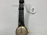 a close up of a watch on a white surface with a price tag