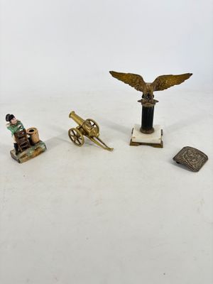 plusieurs figurines représentant un homme assis sur une chaise à côté d'un canon