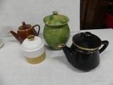 three teapots and a coffee pot on a table