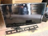 a flat screen tv sitting on the floor next to a keyboard