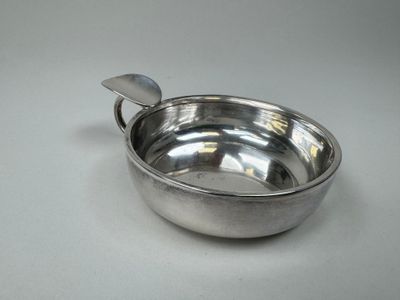 un bol en argent avec une cuillère sur une table