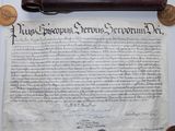 un vieux document, un stylo et quelques pièces de monnaie posés sur une table