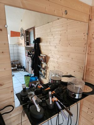 un plan de travail noir sur lequel sont posés des casseroles et des poêles, dans la cuisine