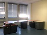 une pièce avec un bureau et deux fenêtres