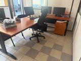 une photo d'un bureau avec deux bureaux et deux écrans