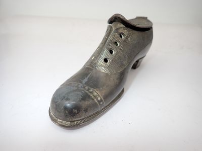 une chaussure argentée posée sur une surface blanche