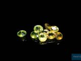 a close up of a bunch of green gems on a black surface