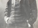 an old photo of a man in a suit and tie posing for a picture