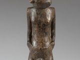 an image of a wooden statue of a man with a hat on his head