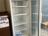a refrigerator that is open in the corner of a room