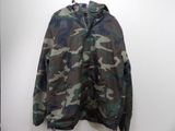 the camouflage jacket is hanging on a hanger on the wall