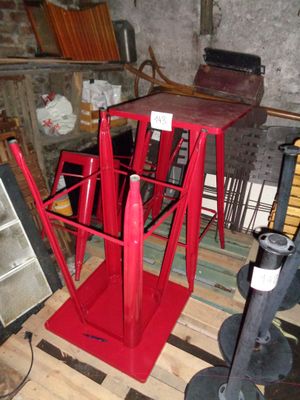 une table rouge sur laquelle est posé un parasol rouge