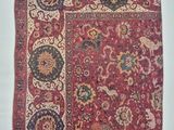 a red rug with a floral design on it
