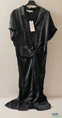 une photo d'une robe noire suspendue à un cintre accroché au mur