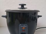 a black crock pot sitting on a counter next to a cup of coffee