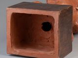 a clay sculpture of a bear sitting next to a small box