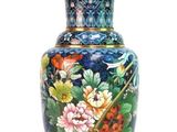 a blue vase with flowers on it sitting on a table