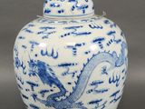un vase bleu et blanc orné d'un dragon sur le couvercle