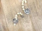 a pearl necklace and a pearl bracelet on a wooden table