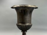 a silver vase that is sitting on a table