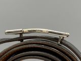 leather belt with a metal buckle on a gray background