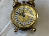 a small clock sitting on top of a white sheet