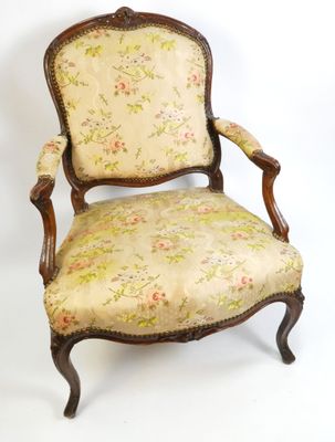 une chaise à l'ancienne avec une assise rembourrée à motifs floraux