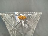 a clear glass vase with a gold medallion on it