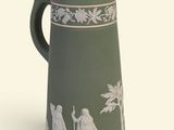 une cafetière verte et blanche avec un couvercle noir