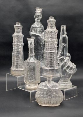 Plusieurs vases et bouteilles en verre transparent sont posés sur un présentoir transparent